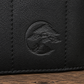 Close-up of a black Bonsai bag, showing a circular embossed logo of a bonsai tree on a wooden surface.