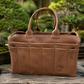 A brown leather Bonsai tote bag with dual top handles and multiple front pockets, displayed on a rustic wooden surface with bonsai trees and gardening tools in the background.